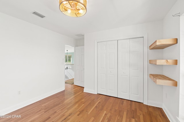 unfurnished bedroom with a closet and hardwood / wood-style floors