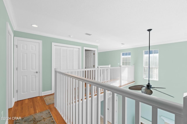 hallway with light hardwood / wood-style floors and crown molding