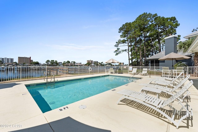 view of swimming pool with a water view and a patio