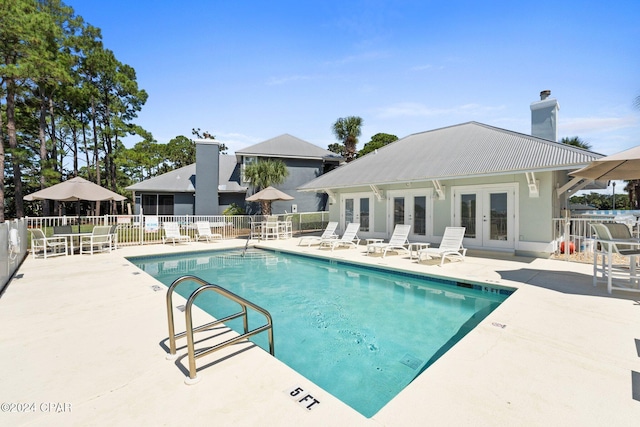 view of swimming pool featuring a patio and french doors