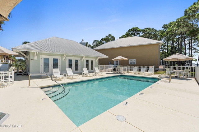 view of swimming pool with french doors and a patio