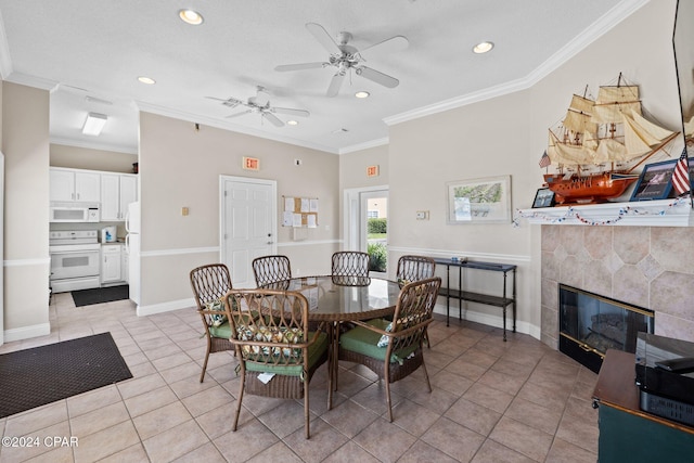 tiled dining space featuring a tiled fireplace, ceiling fan, and ornamental molding