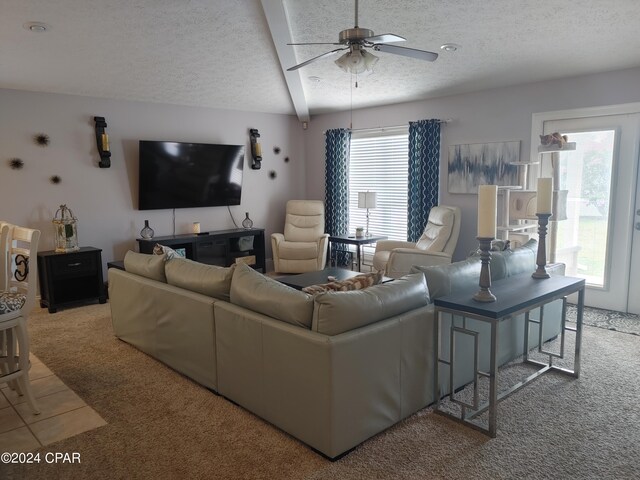 carpeted living room with ceiling fan and a textured ceiling