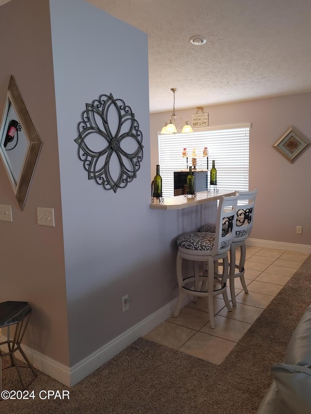 tiled dining space with a textured ceiling