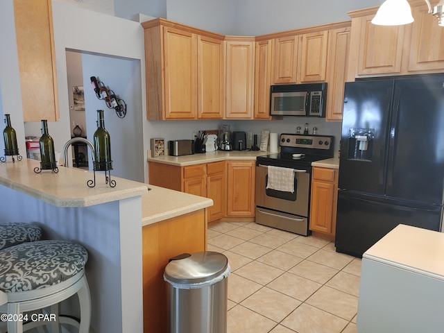 3707 Bay Tree Rd, Lynn Haven, FL 32444 - kitchen with stainless steel appliances, a kitchen breakfast bar, light tile patterned floors, a peninsula, and light countertops