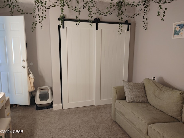 living room with a barn door and carpet floors