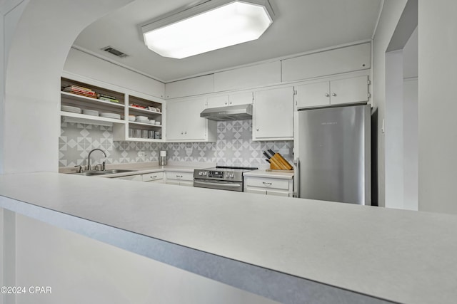 kitchen with a sink, stainless steel appliances, visible vents, under cabinet range hood, and backsplash