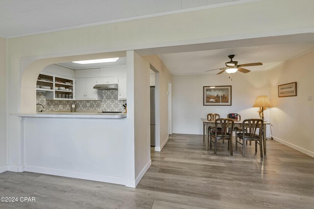 2406 Sewanee St, Lynn Haven, FL 32444 - kitchen featuring backsplash, ornamental molding, under cabinet range hood, and wood finished floors