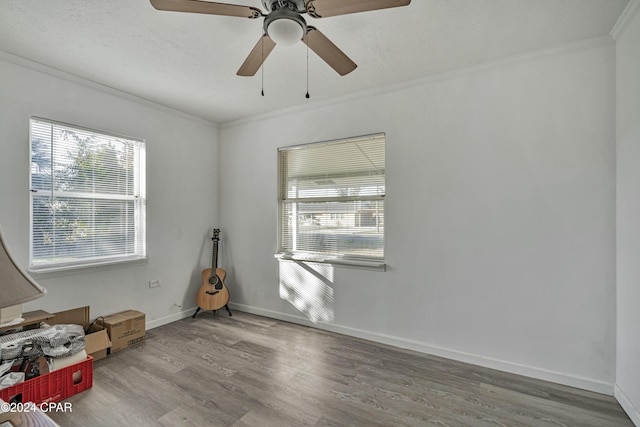 spare room featuring a textured ceiling, ceiling fan, wood-type flooring, and ornamental molding