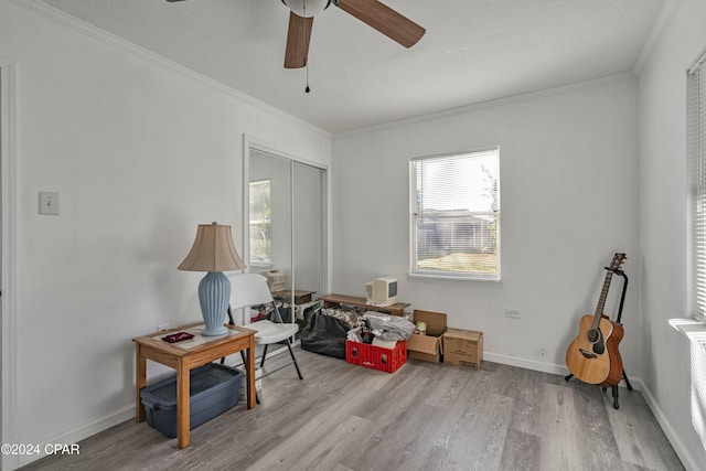 miscellaneous room with ceiling fan, crown molding, and light hardwood / wood-style flooring