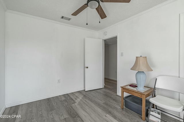 sitting room featuring visible vents, wood finished floors, a ceiling fan, and ornamental molding