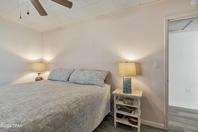 bedroom featuring dark hardwood / wood-style flooring, ceiling fan, and ornamental molding