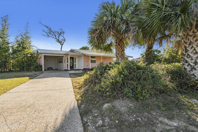 2406 Sewanee St, Lynn Haven, FL 32444 - view of front of house with driveway, an attached carport, and metal roof