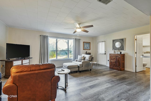 living room featuring hardwood / wood-style floors, ceiling fan, crown molding, and washer / clothes dryer