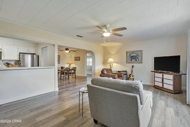 living room with ceiling fan and light wood-type flooring