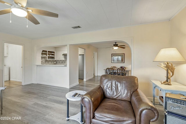 living room with ceiling fan, washer / dryer, and wood-type flooring