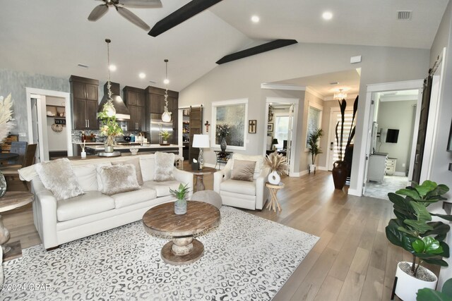 living room featuring ceiling fan, light hardwood / wood-style floors, and vaulted ceiling