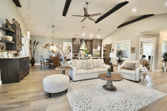 living room featuring lofted ceiling with beams, light hardwood / wood-style floors, and ceiling fan