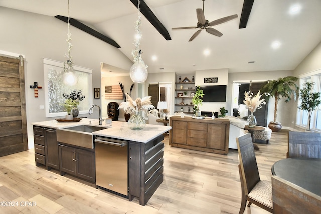 kitchen featuring pendant lighting, vaulted ceiling with beams, a center island with sink, and light stone counters