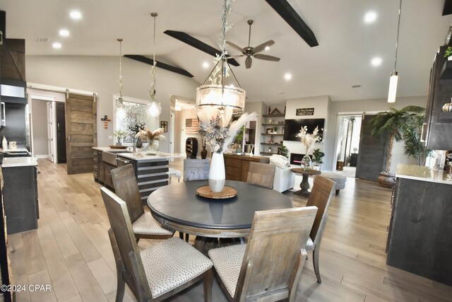 dining room with lofted ceiling with beams, light wood-type flooring, and ceiling fan with notable chandelier