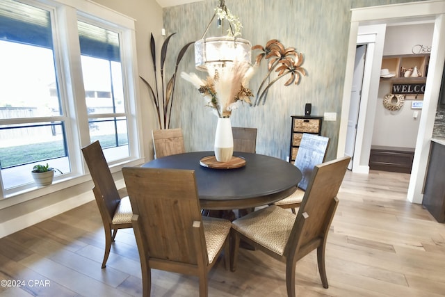 dining room with light wood-type flooring and an inviting chandelier