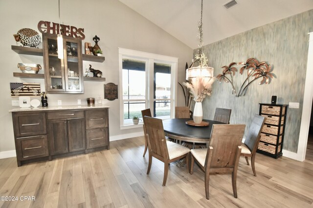 dining room featuring light hardwood / wood-style floors and lofted ceiling