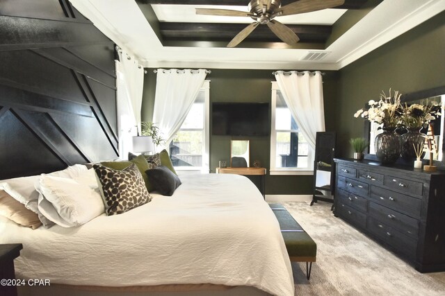 bedroom featuring light carpet, a tray ceiling, and ceiling fan