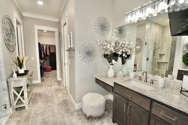 bathroom with vanity, a shower with shower door, and ornamental molding