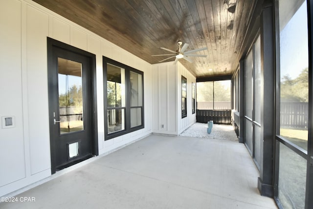 unfurnished sunroom with ceiling fan and wooden ceiling