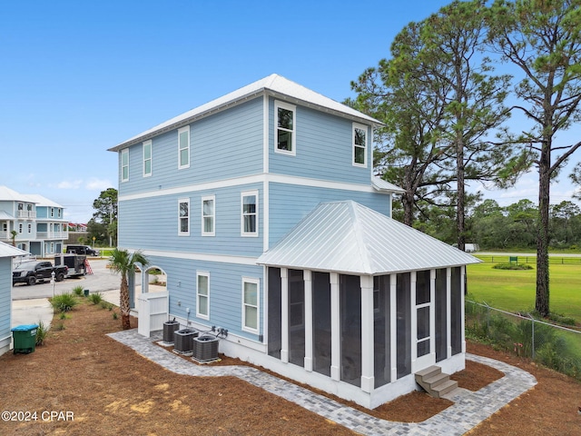 back of house featuring a sunroom and central AC unit