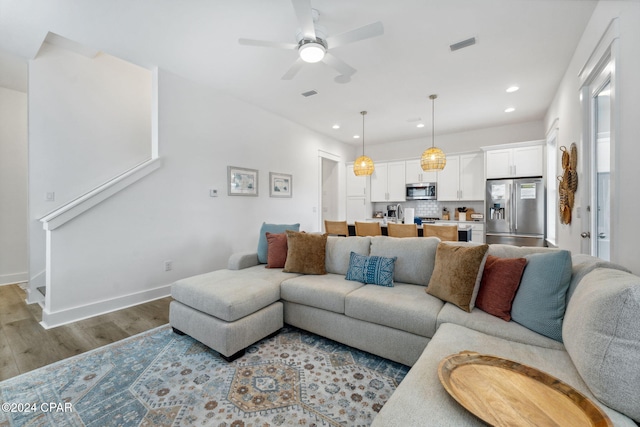 living room featuring ceiling fan and light wood-type flooring