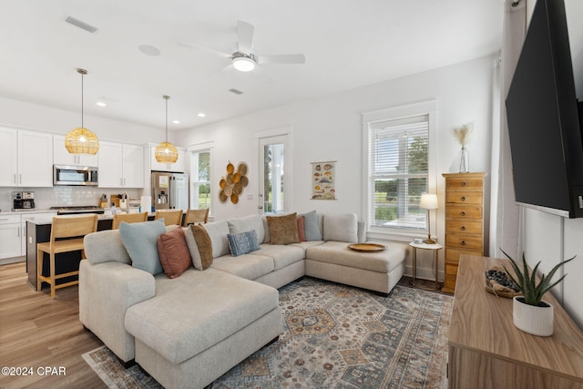 living room featuring ceiling fan and light wood-type flooring