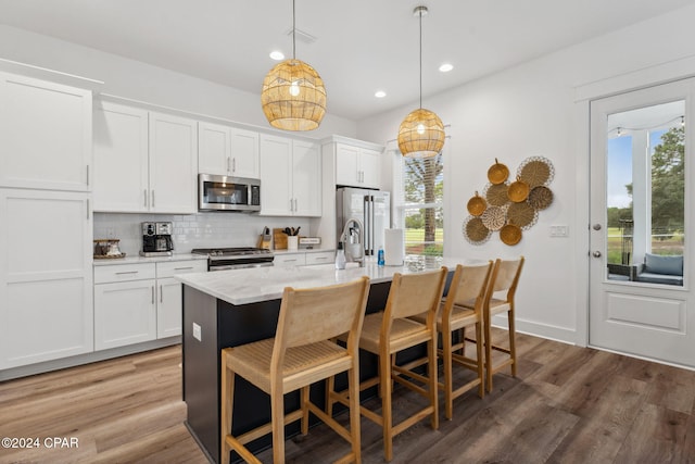 kitchen featuring decorative light fixtures, white cabinetry, stainless steel appliances, and a wealth of natural light