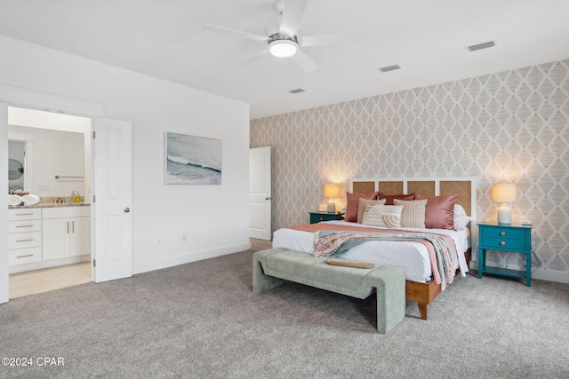 carpeted bedroom featuring ensuite bathroom and ceiling fan