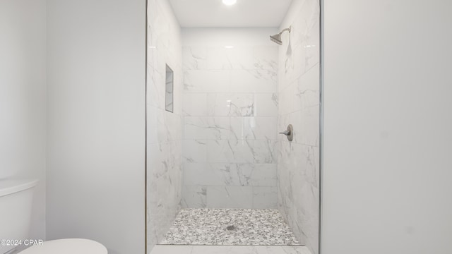 bathroom featuring toilet and tiled shower