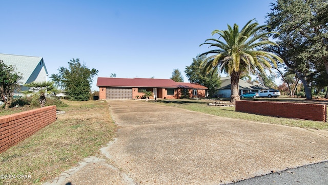 ranch-style house featuring a garage and a front yard