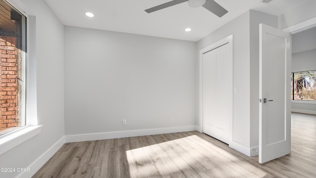 unfurnished bedroom with ceiling fan, light wood-type flooring, and a closet