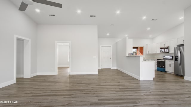 kitchen featuring high vaulted ceiling, hardwood / wood-style flooring, ceiling fan, white cabinetry, and stainless steel appliances