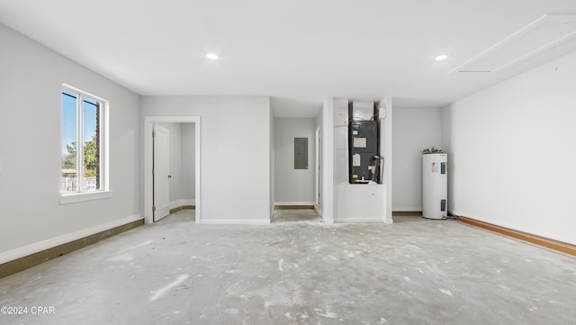 spare room featuring electric panel, heating unit, and water heater