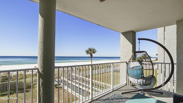 balcony featuring a water view and a beach view