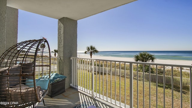 balcony featuring a view of the beach and a water view