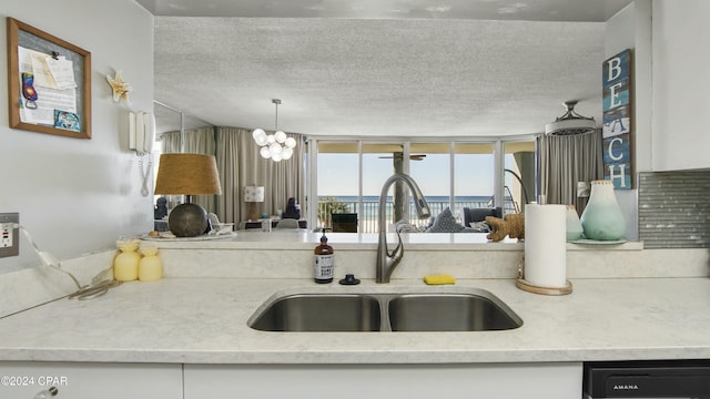 kitchen with dishwashing machine, light stone countertops, sink, and white cabinets