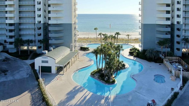 exterior space with a water view, a view of the beach, and a patio