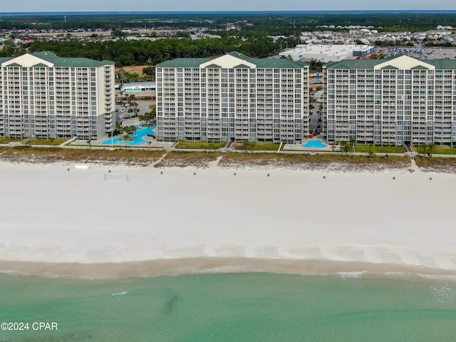 drone / aerial view featuring a water view and a view of the beach