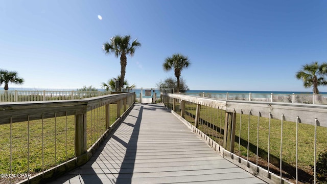 view of property's community featuring a water view, a yard, and a view of the beach