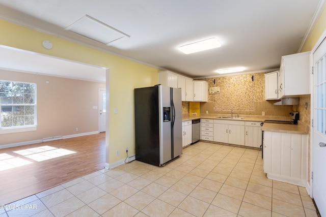 kitchen featuring light tile patterned flooring, white cabinetry, ornamental molding, appliances with stainless steel finishes, and backsplash