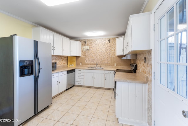 kitchen with sink, white cabinetry, crown molding, stainless steel appliances, and backsplash