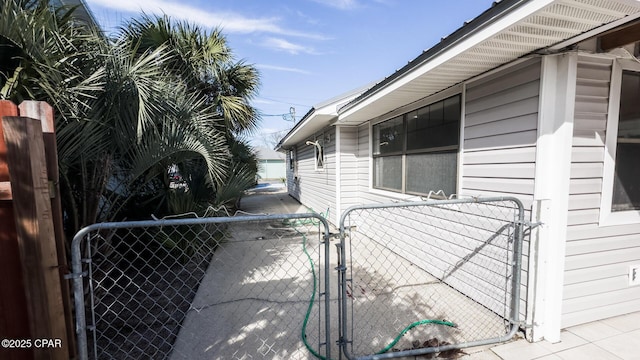 view of side of home featuring a gate and fence