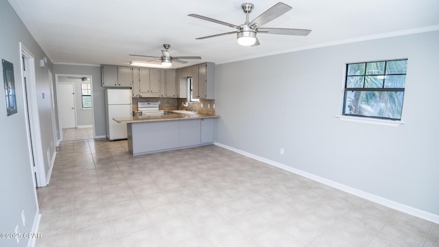 kitchen featuring open floor plan, a peninsula, freestanding refrigerator, and electric stove