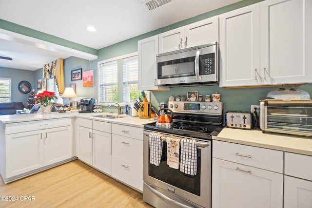 kitchen featuring light hardwood / wood-style flooring, stainless steel appliances, white cabinetry, and sink